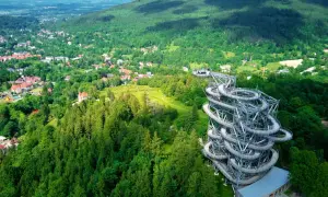 Spiralna wieża widokowa w otoczeniu zielonych górskich lasów. Jedno z ciekawych miejsc w górach, oferujące wspaniałe widoki.