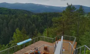 Drewniany punkt widokowy w Karpaczu z widokiem na Karkonosze. Dwie kobiety odpoczywają na tarasie.
