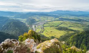 Widok z góry na dolinę z rzeką i miasteczkiem, w oddali majaczą góry. Widok z Trzech Koron.
