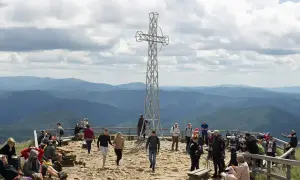 Tłum turystów na szczycie Tarnicy w Bieszczadach, podziwiających rozległą panoramę gór.