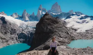 Kobieta na skale podziwia majestatyczne szczyty Patagonii. Firma Patagonia inspiruje do odkrywania piękna natury.