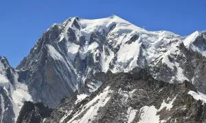 Majestatyczny Mont Blanc, gdzie leży, w Alpach, pokryty śniegiem i lodem, góruje nad skalistymi zboczami.