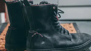 Czarne, znoszone buty zimowe na macie. Szukasz domowych sposobów na śmierdzące buty? Zobacz, jak je odświeżyć!