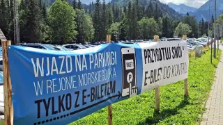 Palenica Białczańska parking: wjazd tylko z e-biletem. Przygotuj swój bilet do kontroli. Tłumy samochodów na tle gór.