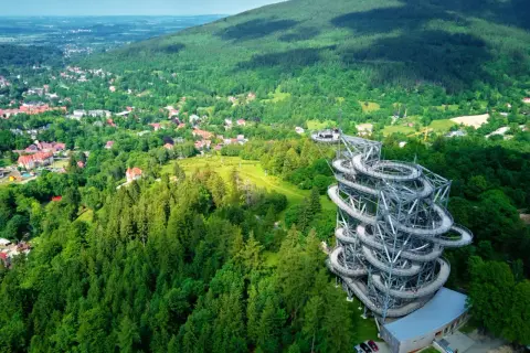 Spiralna wieża widokowa w otoczeniu zielonych górskich lasów. Jedno z ciekawych miejsc w górach, oferujące wspaniałe widoki.