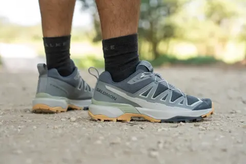 Szare buty trekkingowe Salomon X Ultra 360 na kamienistej ścieżce.