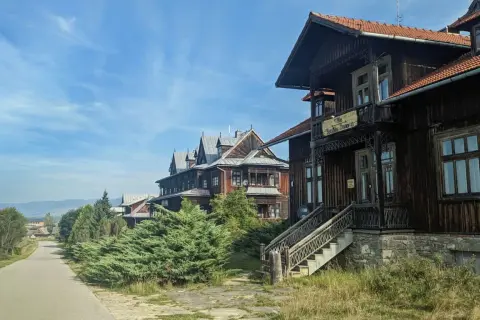 Drewniane wille w osadzie Czorsztyn, z charakterystyczną architekturą i zielenią, zapraszają do podróży w czasie.