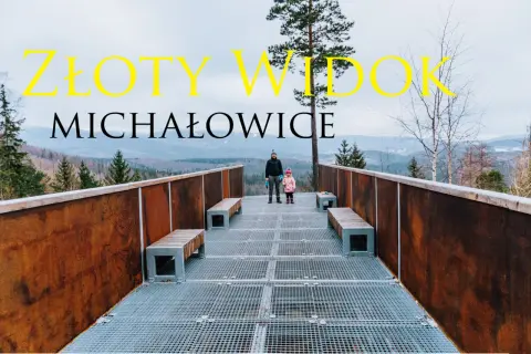 Złoty widok Michałowice. Dwoje ludzi na platformie widokowej z metalową kratownicą i ławkami, w tle góry i las.