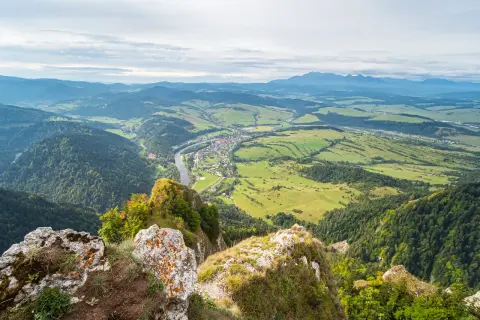 Widok z góry na dolinę z rzeką i miasteczkiem, w oddali majaczą góry. Widok z Trzech Koron.