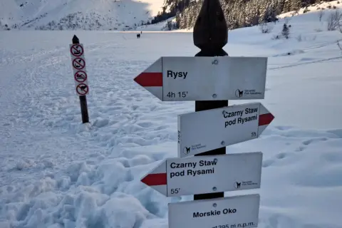 Zimowy szlak w Tatrach. Znaki wskazują drogę na Rysy, Czarny Staw pod Rysami i Morskie Oko.
