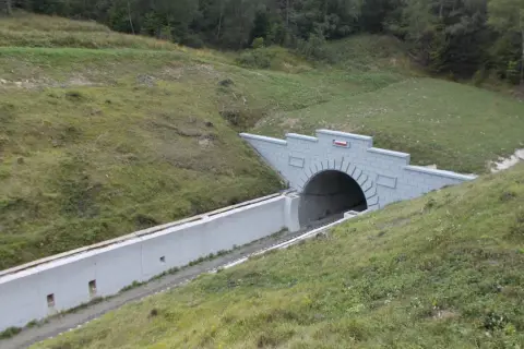 Nowy tunel kolejowy na przełęczy łupkowskiej, wcinający się w zielone zbocze.