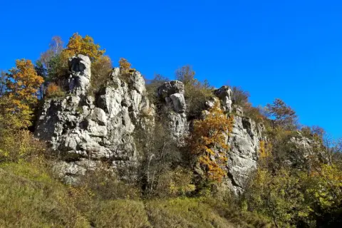 Skały wapienne w jesiennej odsłonie, porośnięte kolorowymi drzewami. Dolina Kluczwody zachwyca o tej porze roku.
