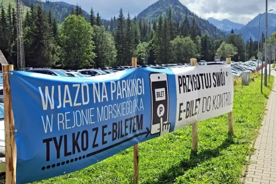 Palenica Białczańska parking: wjazd tylko z e-biletem. Przygotuj swój bilet do kontroli. Tłumy samochodów na tle gór.