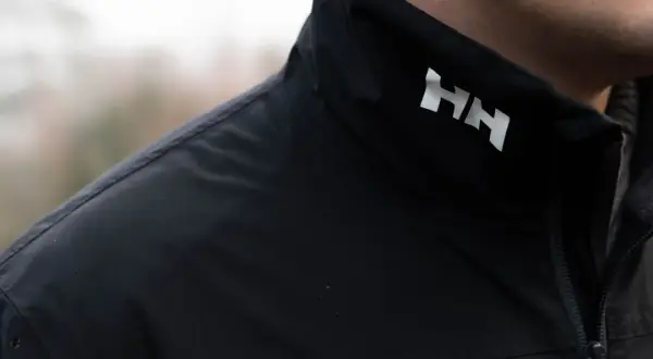 Czarna kurtka z białym logo HH. Helly Hansen co to za firma? To marka odzieży technicznej, idealna na przygody.