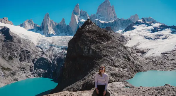 Kobieta na skale podziwia majestatyczne szczyty Patagonii. Firma Patagonia inspiruje do odkrywania piękna natury.