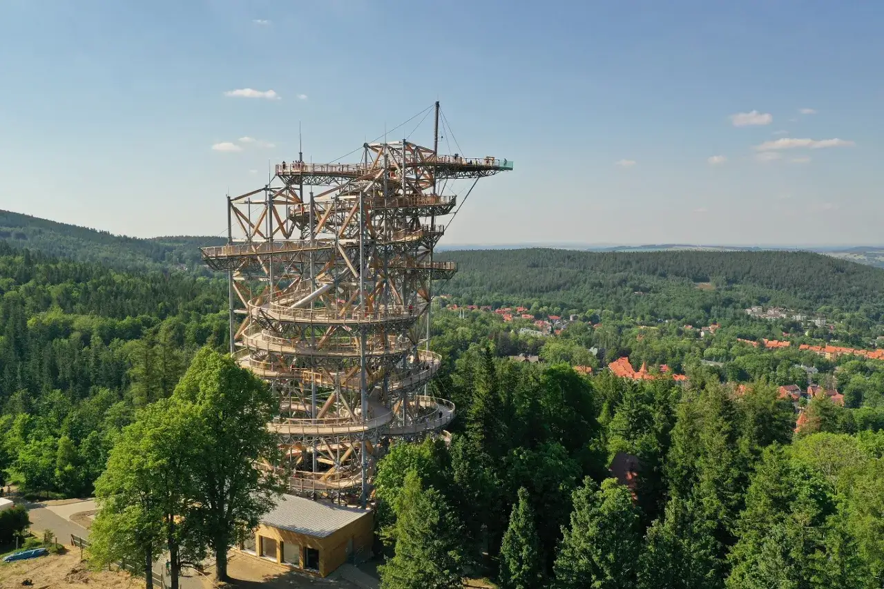 Drewniana konstrukcja sky walk w Świeradowie Zdroju wznosi się ponad lasem, oferując widok na okoliczne wzg&oacute;rza i miasteczko.
