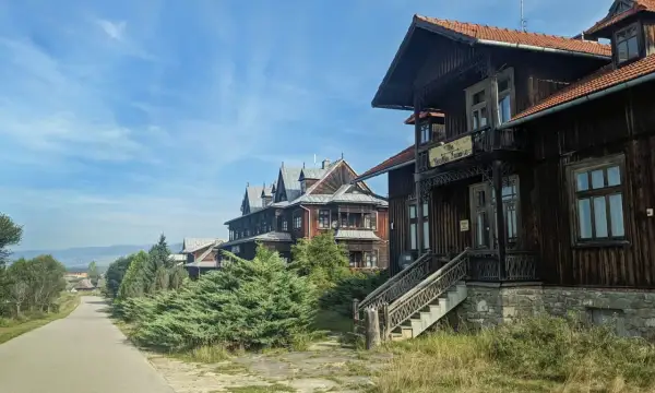 Drewniane wille w osadzie Czorsztyn, z charakterystyczną architekturą i zielenią, zapraszają do podróży w czasie.