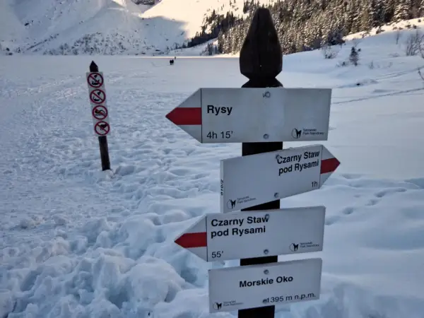 Zimowy szlak w Tatrach. Znaki wskazują drogę na Rysy, Czarny Staw pod Rysami i Morskie Oko.