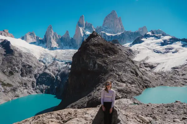Kobieta na skale podziwia majestatyczne szczyty Patagonii. Firma Patagonia inspiruje do odkrywania piękna natury.