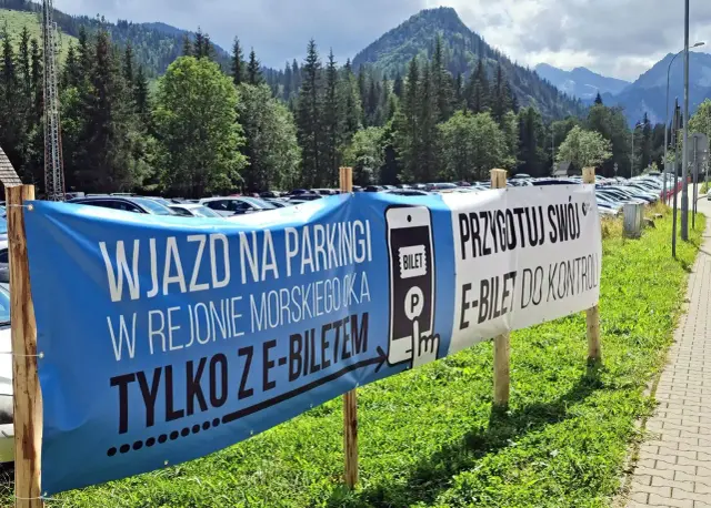 Palenica Białczańska parking: wjazd tylko z e-biletem. Przygotuj swój bilet do kontroli. Tłumy samochodów na tle gór.